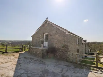 an old brick building with a gate and a fence at The Stable in Lampeter