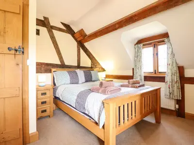 a bedroom with a wooden bed and a window at The Old House in Llanidloes