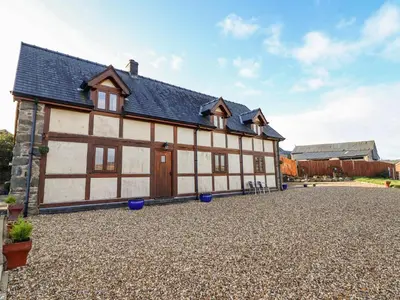 a large white and brown building with a gravel driveway at The Old House in Llanidloes