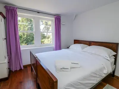 a bedroom with a large white bed with purple curtains at The Pheasantry in Builth Wells