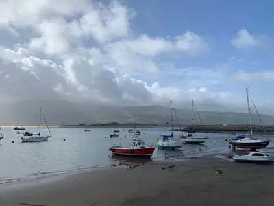 a group of boats sitting in the water on the beach at Central Barmouth Town House - Near Beach - Sleeps up to 16! in Barmouth
