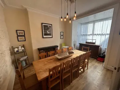 a dining room with a large wooden table and chairs at Central Barmouth Town House - Near Beach - Sleeps up to 16! in Barmouth