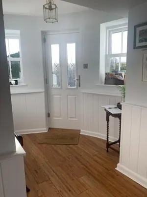 a white room with a door and windows and a wooden floor at Ty Capel in Llanidloes