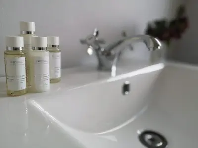 three bottles of moisturizers sit on a bathroom sink at Ty Capel in Llanidloes