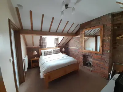 a bedroom with a bed and a brick wall at The Dolfor Inn in Newtown