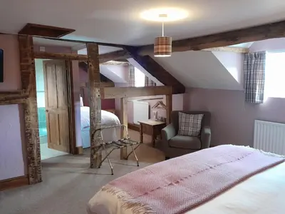 a bedroom with a bed and a chair in a room at The Dolfor Inn in Newtown