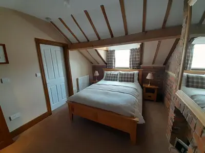 a bedroom with a large bed in a attic at The Dolfor Inn in Newtown