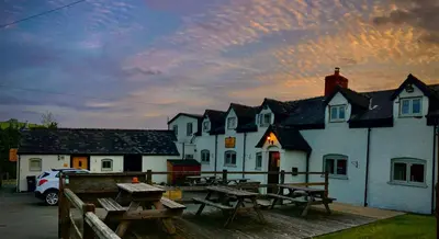 a group of buildings with picnic tables in front of them at The Dolfor Inn in Newtown