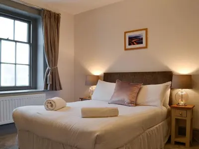 a bedroom with a large bed with a window at Grosvenor House APT 3 in Aberystwyth