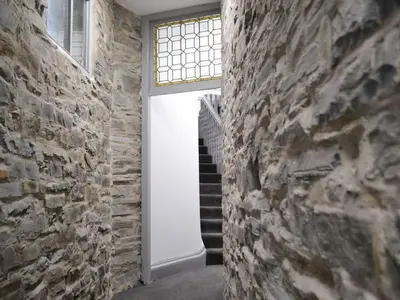 a hallway with a stone wall and a window at Grosvenor House APT 3 in Aberystwyth
