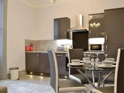 a kitchen with a table and chairs in a kitchen at Grosvenor House APT 3 in Aberystwyth