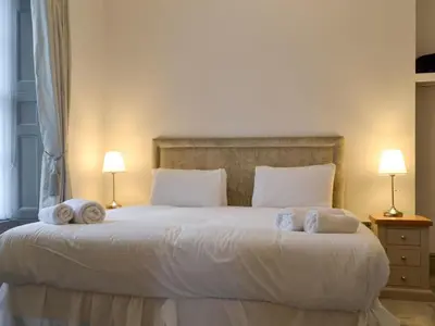 a bedroom with a large bed with towels on it at Grosvenor House APT 3 in Aberystwyth