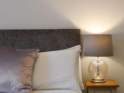 a bedroom with a bed with a lamp on a night stand at Grosvenor House APT 3 in Aberystwyth