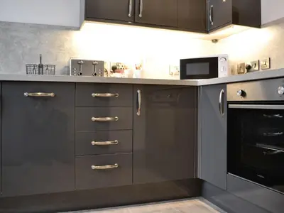 a kitchen with gray cabinets and a microwave oven at Grosvenor House APT 2 in Aberystwyth