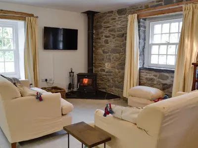 a living room with two white couches and a fireplace at The Mill in Tregaron
