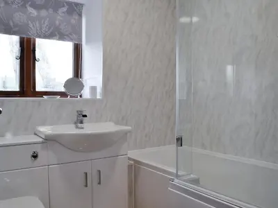 a white bathroom with a sink and a shower at Trefechan in Pumpsaint