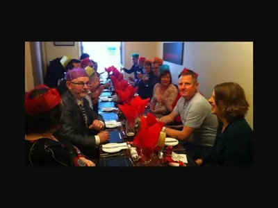 a group of people sitting at a long table with red napkins at The Old Bell in Shrewsbury