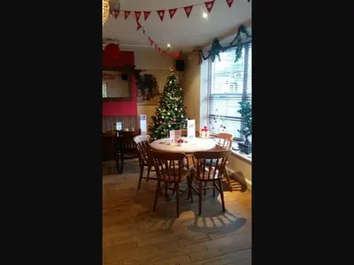 a dining room with a christmas tree and a table and chairs at The Old Bell in Shrewsbury