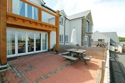 a patio with a picnic table and an umbrella at Cambrian View in Aberystwyth