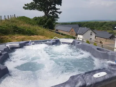 a hot tub with two fountains and water at Brynhyfryd in Aberystwyth