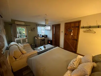 a living room with two couches and a table at Pear Tree Cottage Courtyard in Shrewsbury