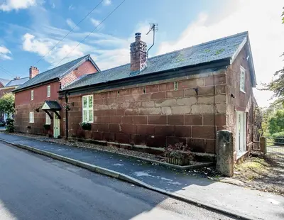 an old brick building on the side of a street at Pear Tree Cottage Courtyard in Shrewsbury