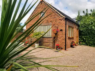 a brick house with a gate and flowers on it at The Snicketts in Ludlow