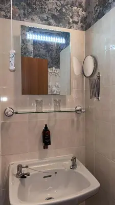 a bathroom with a sink and a mirror at Greylands Guest House in Llandrindod Wells