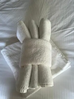 a pile of white towels on a bed at Greylands Guest House in Llandrindod Wells
