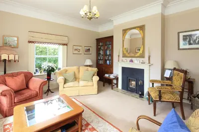 a living room with two chairs and a fireplace at The Old Vicarage Dolfor in Newtown