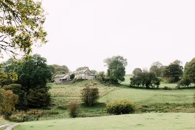 an old house on a hill in a field at The Stable at Ty Beic in Bala