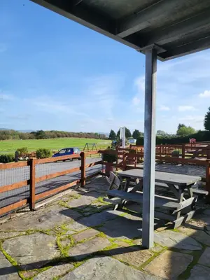 a picnic table next to a fence with a field at The Hay Suite in Aberystwyth