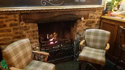 two chairs sitting in front of a fireplace at The Wheatsheaf Inn in Ludlow
