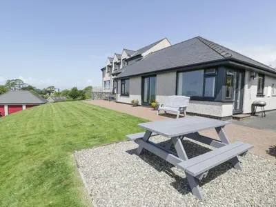 a picnic table in front of a house at Bryn Coch Bach in Dyffryn