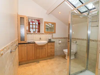 a bathroom with a shower and a sink and a toilet at Craig Y Deryn in Tywyn