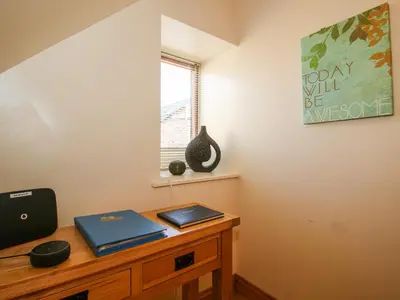 a room with a desk with two laptops on it at The Mill House in Shrewsbury