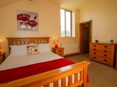 a bedroom with a wooden bed and a dresser at The Mill House in Shrewsbury