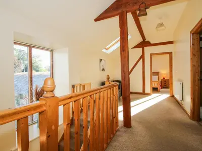 a wooden staircase in a house with a large window at The Mill House in Shrewsbury