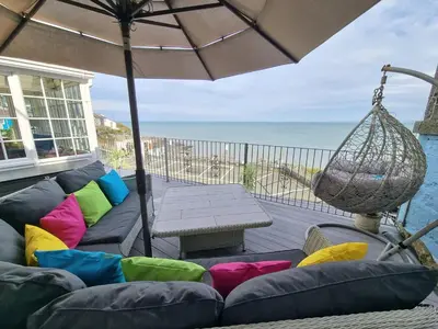a patio with a couch and an umbrella and a table at The Sup Shack Wellington Inn in New Quay