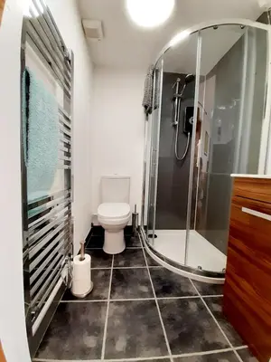 a bathroom with a toilet and a glass shower at Little Smithy in Shrewsbury