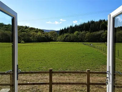 a view of a large field from a window at Abergwynant Farm Glamping & Apartments in Dolgellau