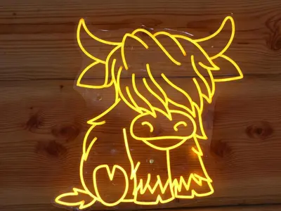 a neon sign of a cow on a wooden wall at Abergwynant Farm Glamping & Apartments in Dolgellau