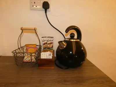 a black tea kettle and a basket on a table at Abergwynant Farm Glamping & Apartments in Dolgellau