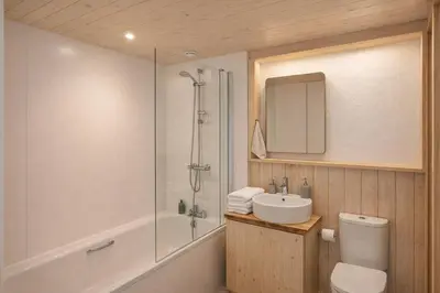 a bathroom with a shower and a toilet and a sink at Abergwynant Farm Glamping & Apartments in Dolgellau
