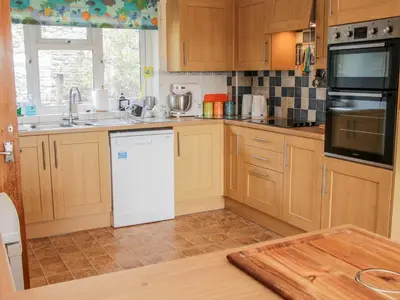 a kitchen with wooden cabinets and a white refrigerator at Lane House in Bishops Castle
