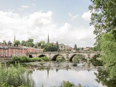 a bridge over a river in a city at Ensdon Lea Cottage in Shrewsbury