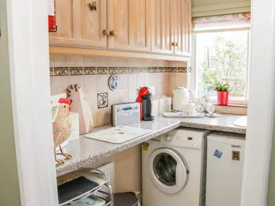 a kitchen with a washer and dryer on a counter at Ensdon Lea Cottage in Shrewsbury