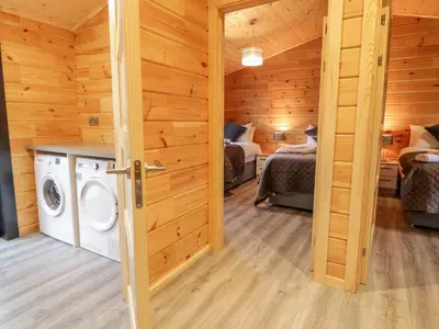 a laundry room with a washer and dryer in a cabin at Bryn Eiddon Log Cabin in Machynlleth