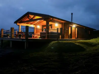 a small cabin with a lit up roof at night at Bryn Eiddon Log Cabin in Machynlleth
