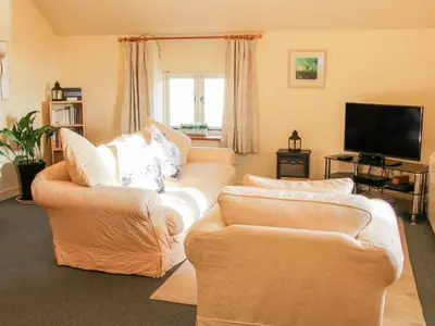 a living room with two couches and a flat screen tv at Stiperstones View in Shrewsbury